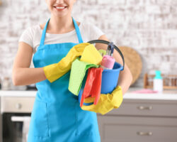 Female,janitor,with,cleaning,supplies,in,kitchen
